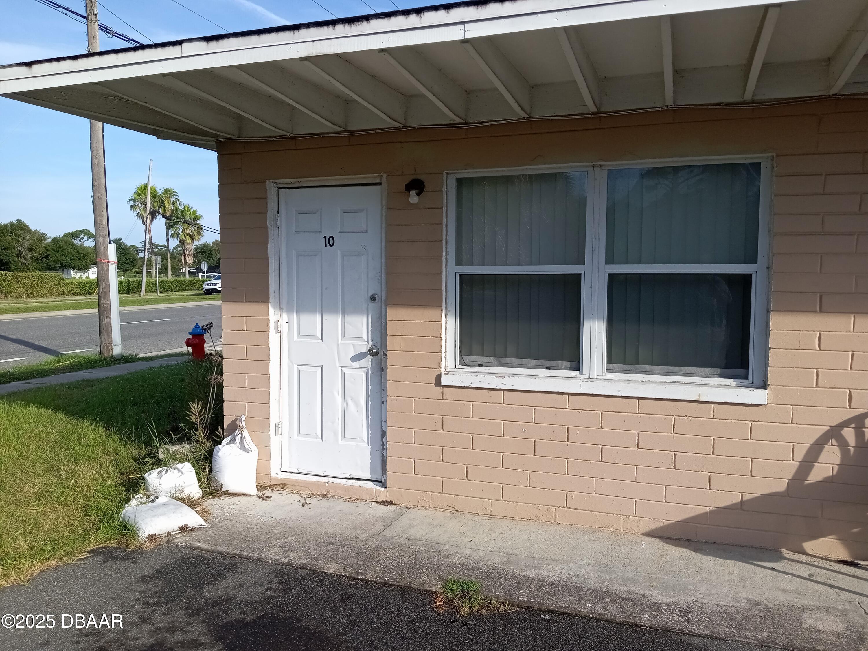 703 South Ridgewood Avenue, Unit 10 Edgewater, FL 32132 - Photo 1 of 5 a front view of a house with a yard