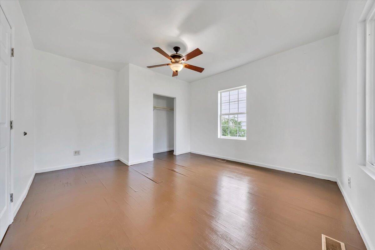 1013 Jamison Avenue Southeast Roanoke, VA 24013 - Photo 6 of 20 an empty room with wooden floor ceiling fan and windows