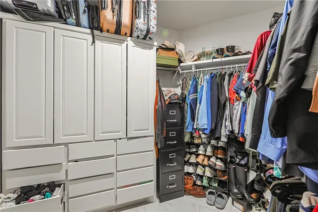 a view of walk in closet with clothes