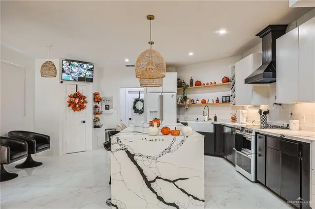 a kitchen view of a dining table chairs sink and stainless steel appliances