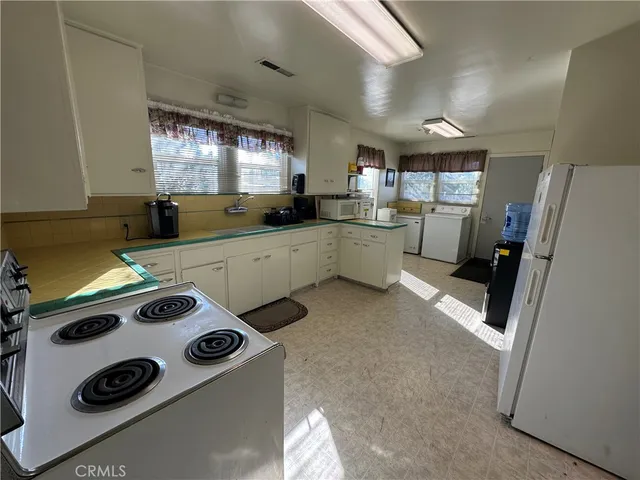 a kitchen with a sink a stove a refrigerator and cabinets