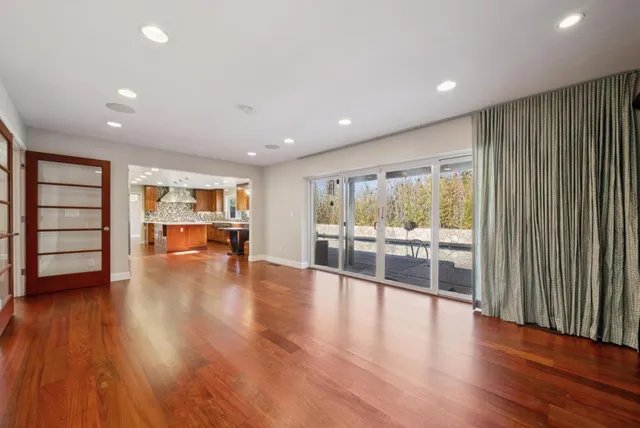 a view of an empty room with wooden floor
