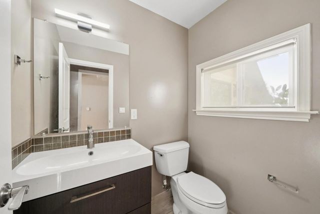 a backyard of a house with potted plants and wooden fence