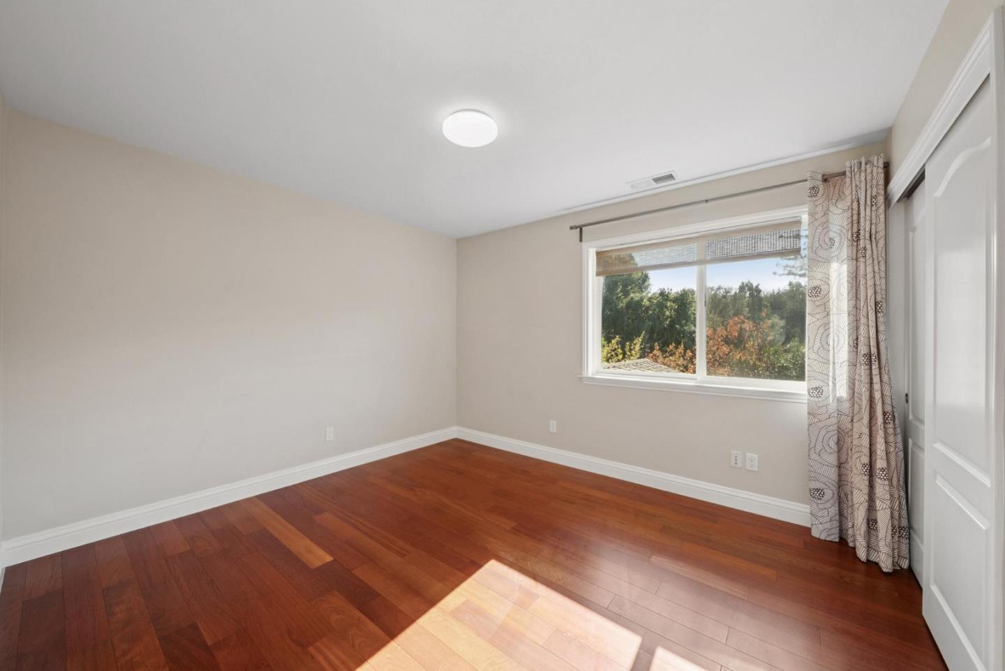 900 Highlands Circle Los Altos, CA 94024 - Photo 48 of 76 a view of an empty room with wooden floor and a window
