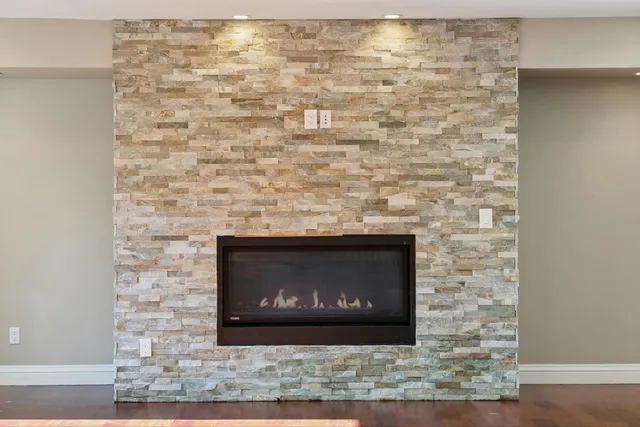 a view of an empty room with a fireplace and a window