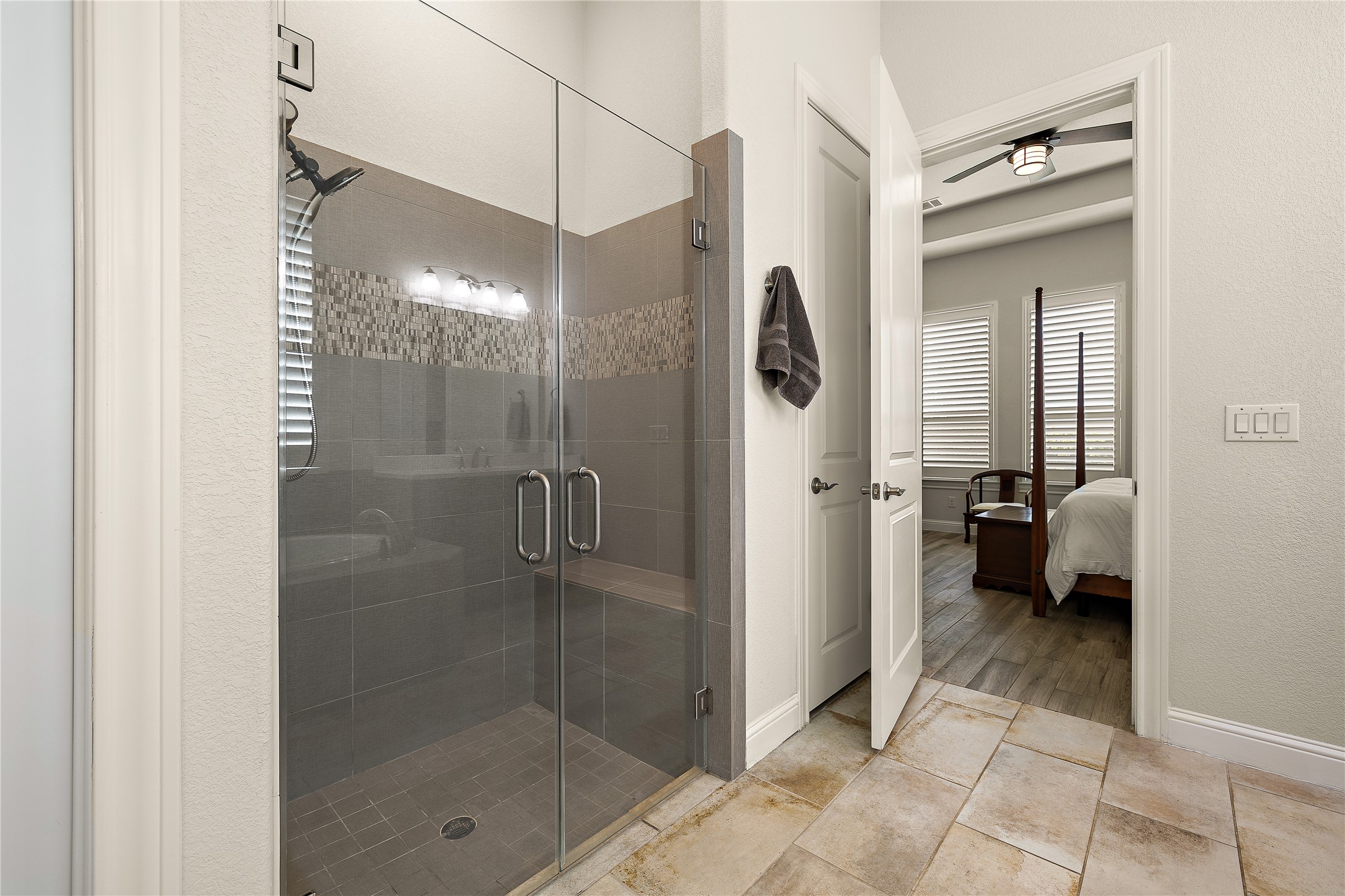 1716 Siena Sunset Road Leander, TX 78641 - Photo 19 of 28 The glass-enclosed shower stands apart from the tub, with tile surround, enclosed by framelss glass.