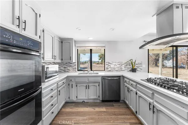 a kitchen with stainless steel appliances a sink stove and cabinets