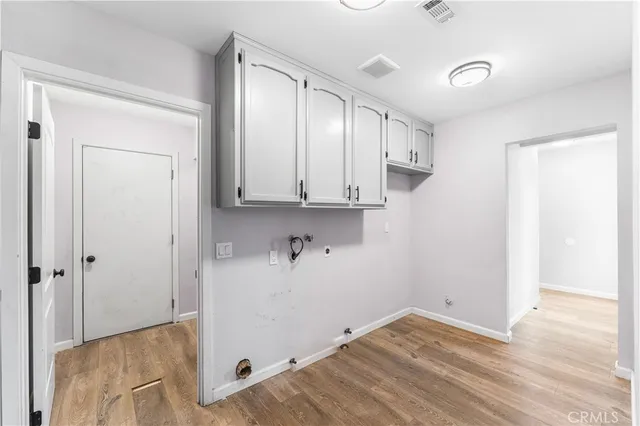 a view of a kitchen with white cabinets and wooden floor