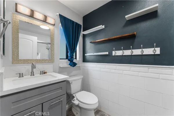 a bathroom with a sink vanity mirror and toilet