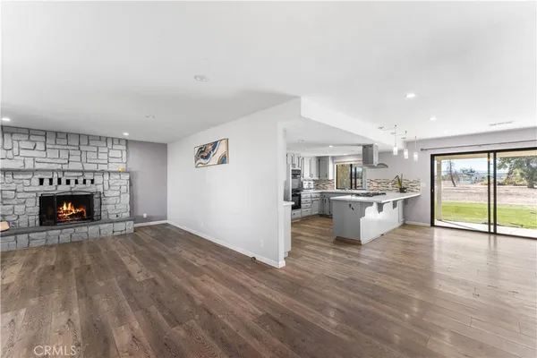 a view of kitchen with a fireplace and wooden floor