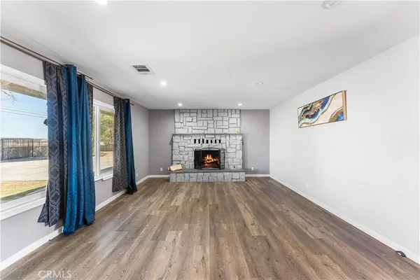 a view of an empty room with a fireplace and a window