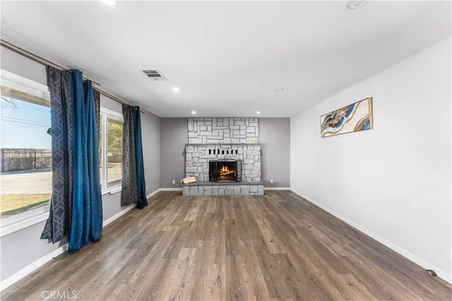 a view of an empty room with a fireplace and a window