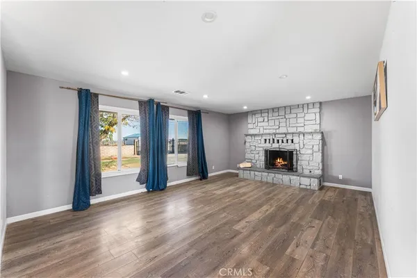 a view of an empty room with a fireplace and a window