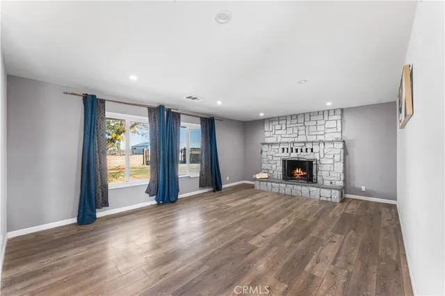 a view of an empty room with a fireplace and a window