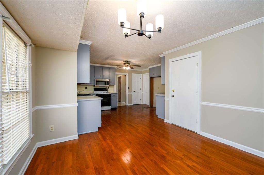 6420 Phillips Place Lithonia, GA 30058 - Photo 16 of 40 a view of a kitchen with a sink and dishwasher a refrigerator with wooden floor