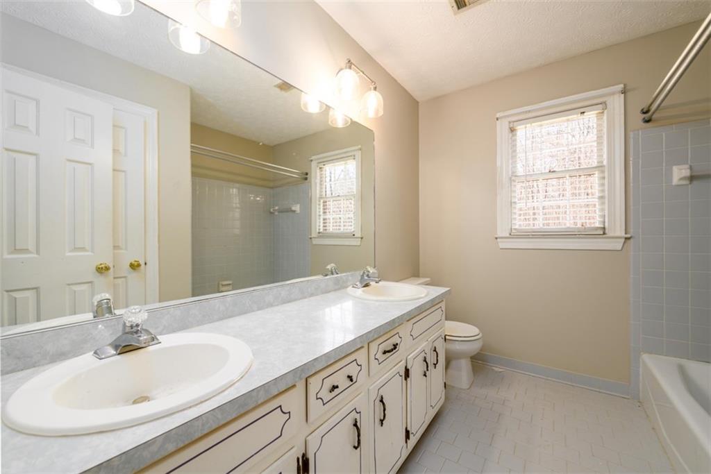 6420 Phillips Place Lithonia, GA 30058 - Photo 32 of 40 a bathroom with a double vanity sink and a mirror