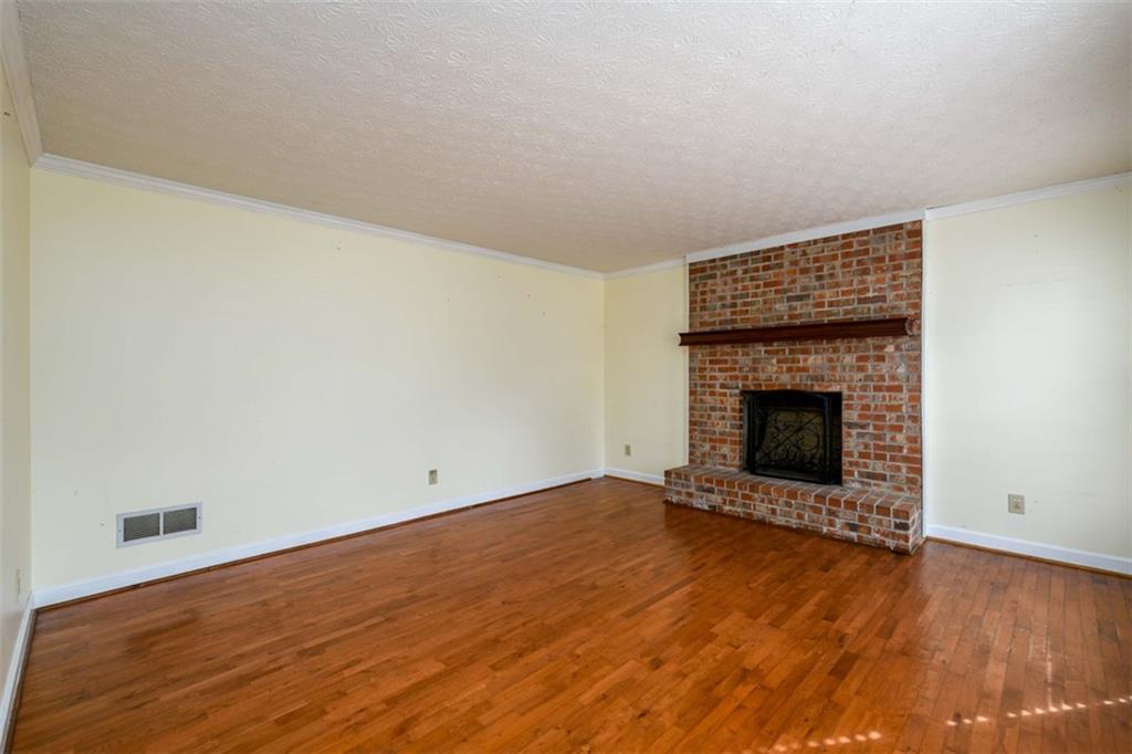 6420 Phillips Place Lithonia, GA 30058 - Photo 7 of 40 a view of an empty room with wooden floor and a fireplace