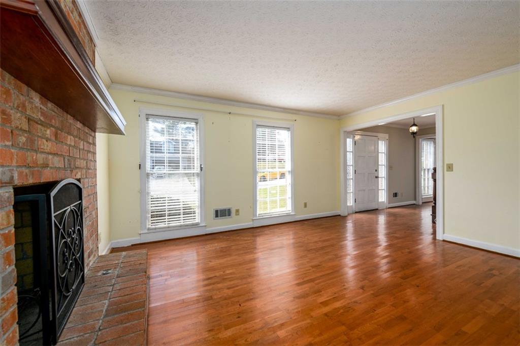 6420 Phillips Place Lithonia, GA 30058 - Photo 8 of 40 a view of empty room with wooden floor and fireplace