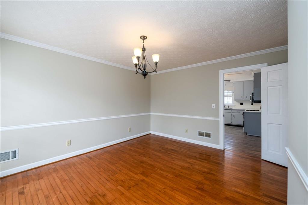 6420 Phillips Place Lithonia, GA 30058 - Photo 9 of 40 a view of a room with wooden floor staircase and a kitchen space