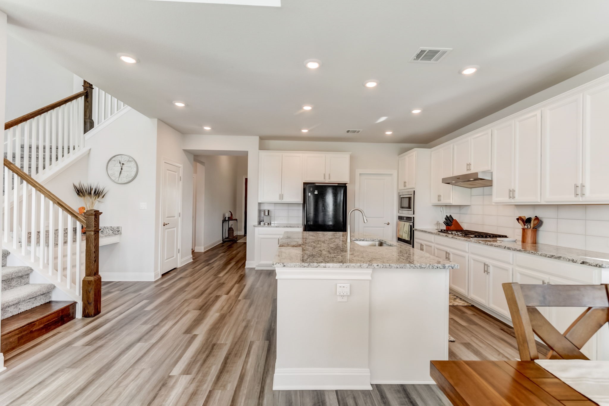 2121 Prairie Oaks Drive Georgetown, TX 78628 - Photo 14 of 40 a large white kitchen with wooden floor and a sink