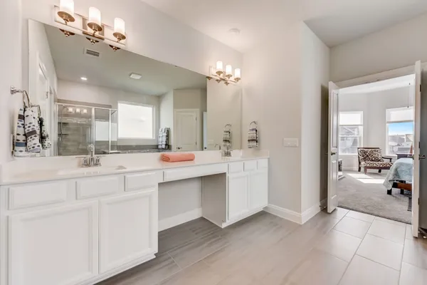 a spacious bathroom with a double vanity sink a mirror a vanity and a bathtub
