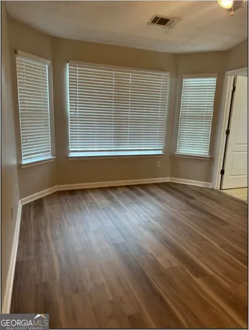 a view of wooden floor and windows in a room