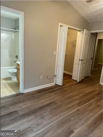 a view of empty room with wooden floor and window