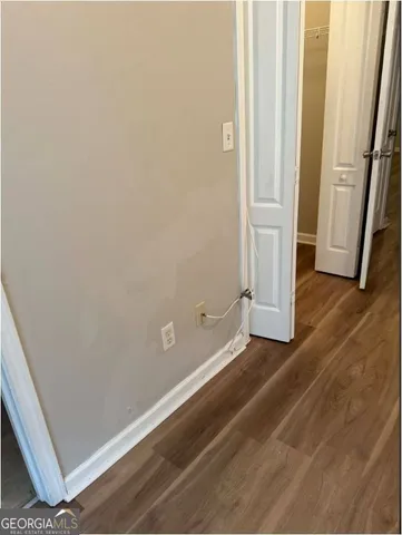 an empty room with wooden floor and entrance