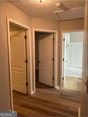 an empty room with wooden floor & closet area