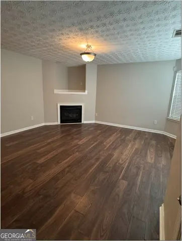 a view of a livingroom with wooden floor and a fireplace