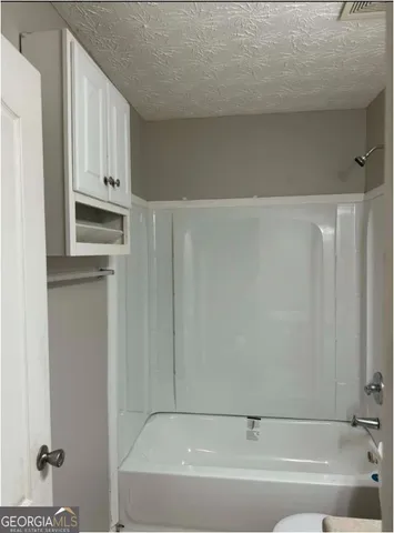 a bathroom with bathtub and window