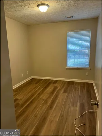 a view of a room with wooden floor and a window