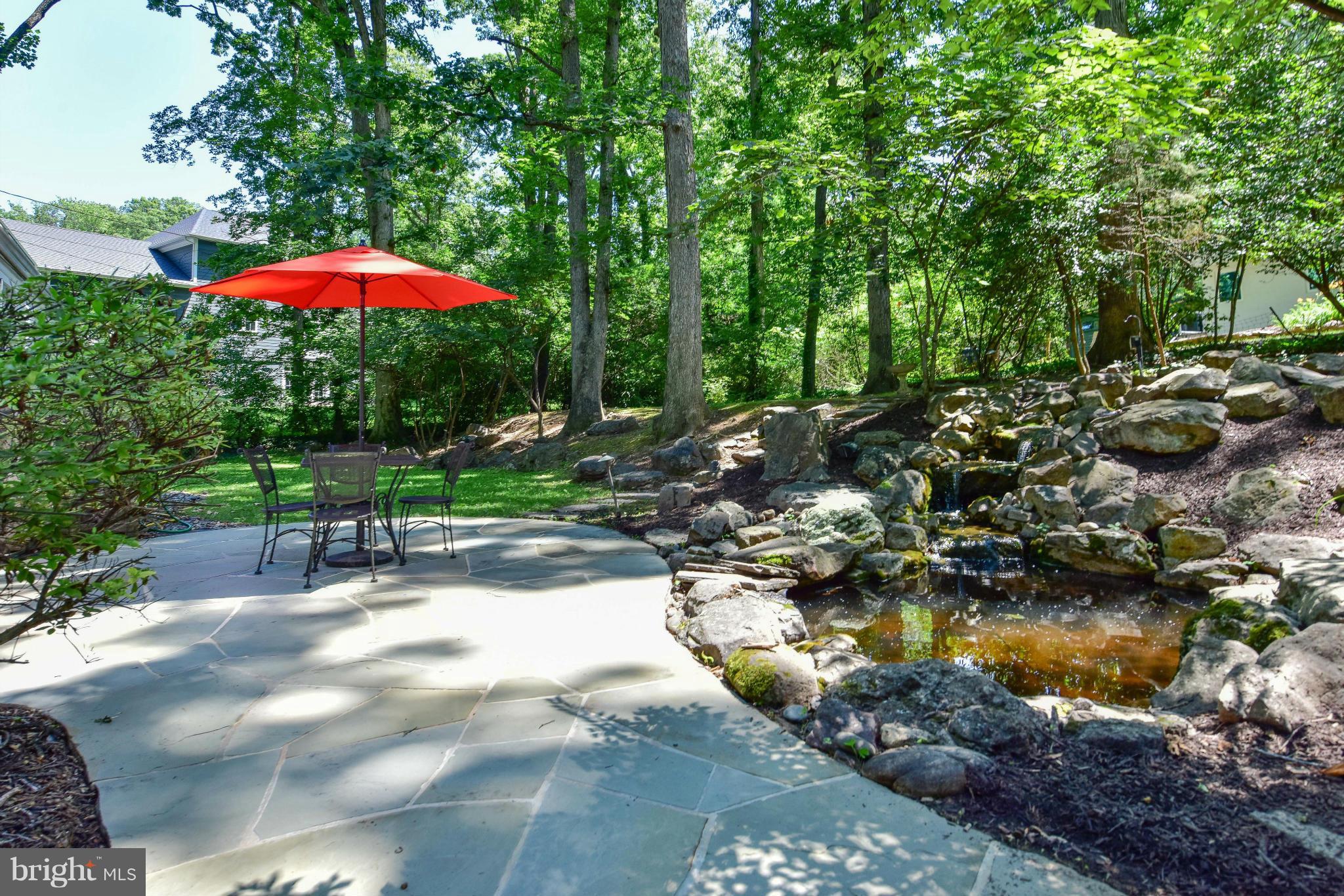1312 Namassin Road Alexandria, VA 22308 - Photo 24 of 30 a backyard of a house with table and chairs under an umbrella