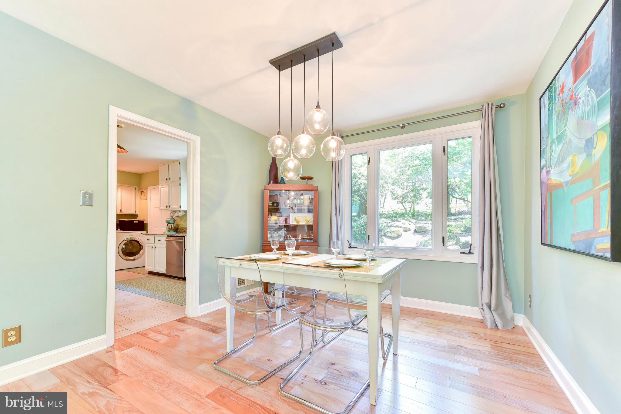 1312 Namassin Road Alexandria, VA 22308 - Photo 7 of 30 a dining room with wooden floor a chandelier a wooden table and chairs