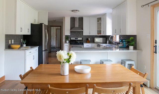 a kitchen with stainless steel appliances granite countertop a dining table and chairs