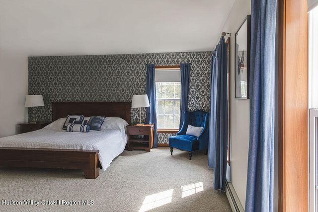 a bedroom with a bed chair and a window