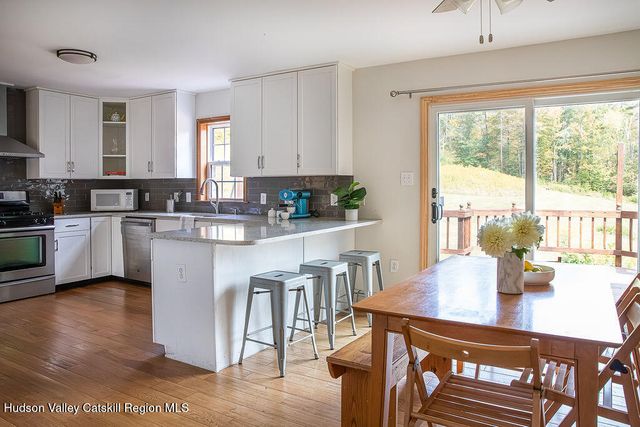 a kitchen with a dining table chairs and view living room
