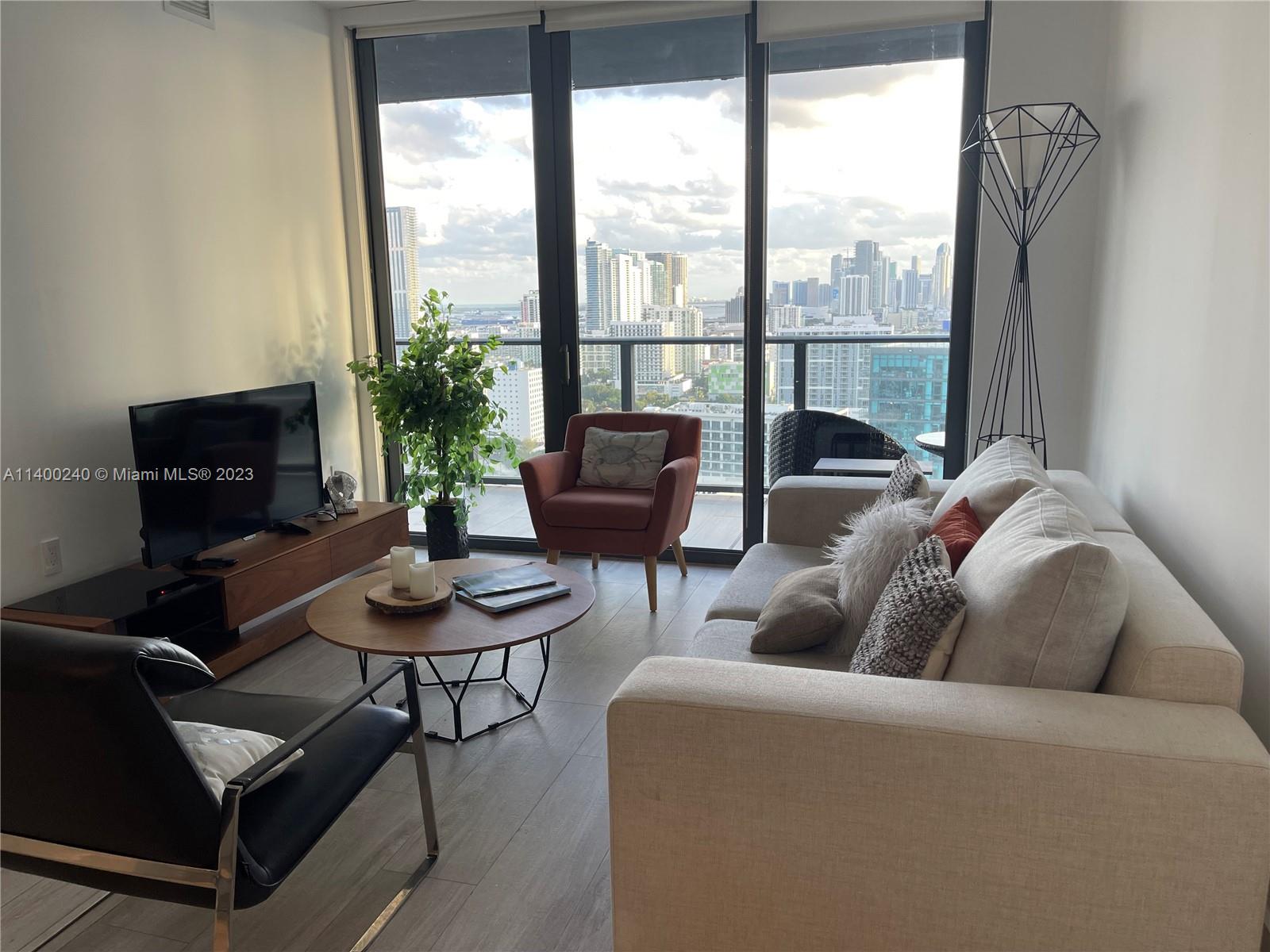 a living room with furniture and a potted plant
