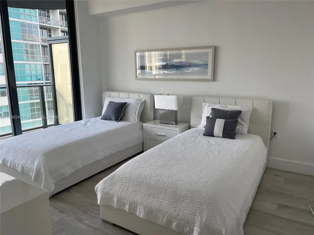 a bedroom with two beds and a painting on the wall