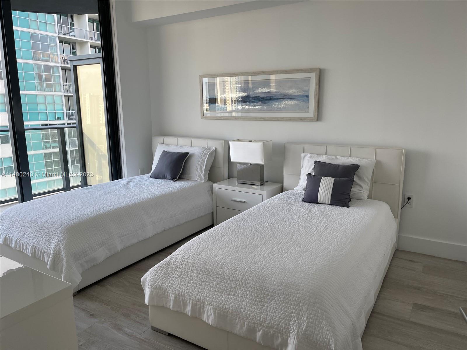 121 Northeast 34th Street, Unit 2802 Miami, FL 33137 - Photo 18 of 25 a bedroom with two beds and a painting on the wall