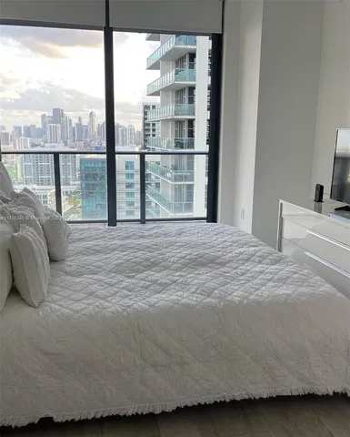 a large bed sitting in a bedroom next to a window