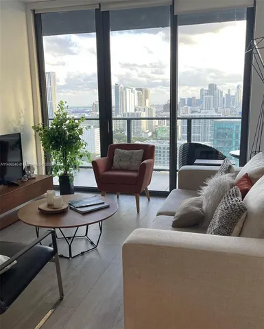 a living room with furniture and a potted plant