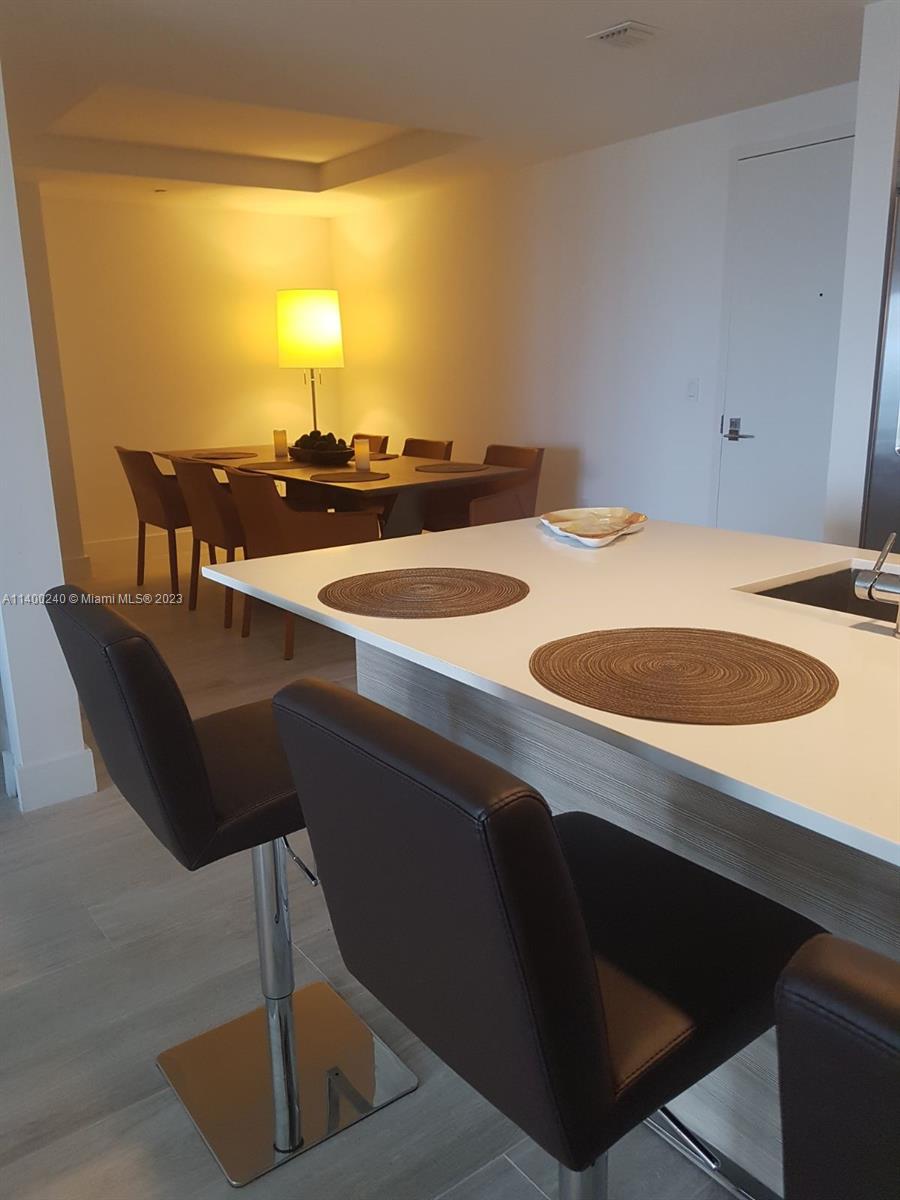 121 Northeast 34th Street, Unit 2802 Miami, FL 33137 - Photo 25 of 25 a dining room with table chairs and a sink