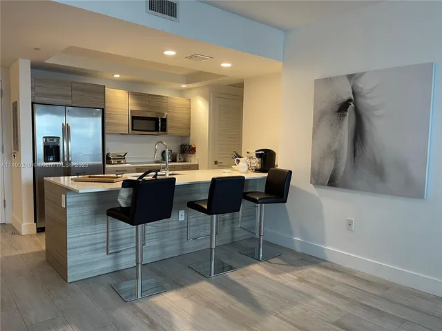a kitchen with a sink and chairs