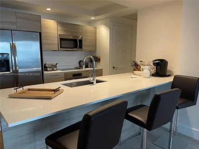 a kitchen with a table chairs refrigerator and microwave
