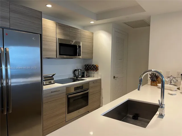 a kitchen with a sink and a stove top oven with wooden floor