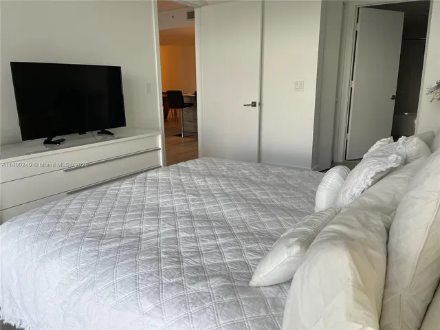a bedroom with a bed and a flat screen tv
