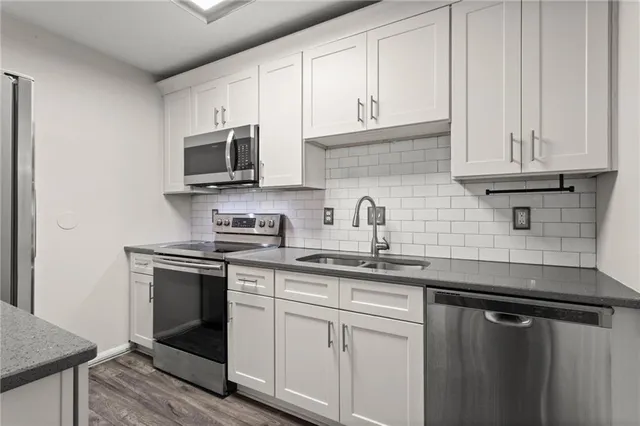 a kitchen with stainless steel appliances granite countertop a sink stove and microwave