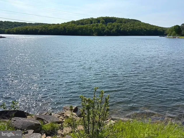 a view of a patio with couches table and chairs with wooden floor and fence