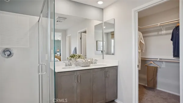 a bathroom with a double vanity sink mirror and shower